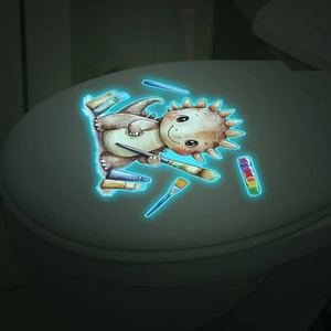 Sticker dinosaure luminescent avec effet bleu brillant sur un couvercle de toilette