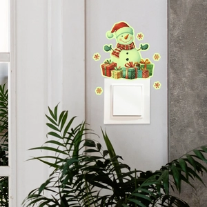Luminous Christmas snowman wall sticker with gift boxes and golden snowflakes near a switch