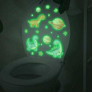 Luminous cartoon dinosaur and space themed glowing stickers on a bathroom toilet lid