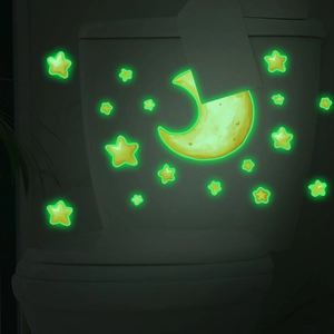 Glow in the dark moon and stars wall stickers shining green on a toilet tank
