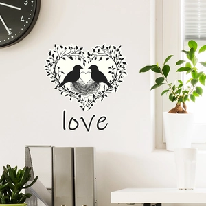 Détail de l'autocollant mural silhouette oiseaux et branche en cœur dans un décor
