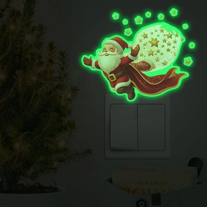 Glow-in-the-dark Christmas Santa and stars sticker glowing bright green on a wall switch