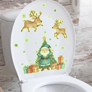 Glow-in-the-dark Christmas stickers with reindeer and Santa on a white toilet lid