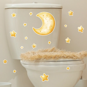 Luminous crescent moon and stars watercolor stickers applied on white toilet surfaces
