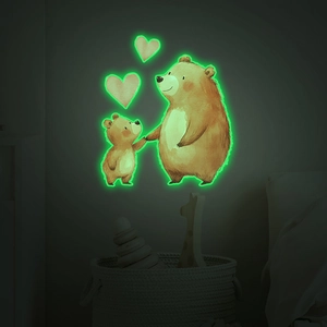 Luminous wall sticker showing glowing cartoon bears and hearts in a dark bedroom