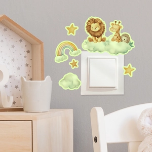 Dettaglio di adesivi luminosi con leone, giraffa e arcobaleno intorno a un interruttore