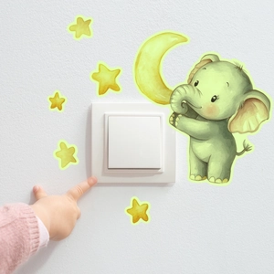 Glow-in-the-dark elephant and moon light switch decal applied on a white bedroom wall