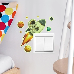 Glow-in-the-dark astronaut on rocket wall sticker next to a light switch in kids room