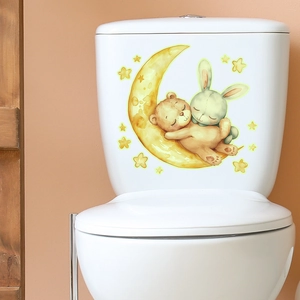 Glow in the dark cartoon bear and rabbit wall stickers applied on white toilet tank