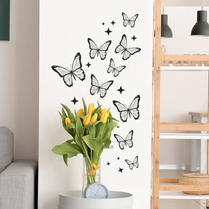 Décoration murale moderne avec stickers papillons noirs et étoiles sur un mur blanc