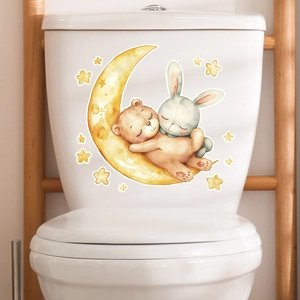 Detailed view of glowing bear and rabbit on moon sticker applied on a white toilet