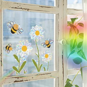 Rainbow effect window decals featuring floral and bee designs on a rustic window