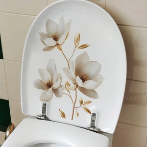 Elegant white toilet seat with golden magnolia flower patterns and metal hinges