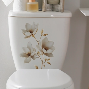 Detailed view of white floral wall stickers with gold leaves on a ceramic toilet tank surface