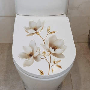 Detail of white magnolia flower wall decal with golden leaves on a ceramic toilet lid