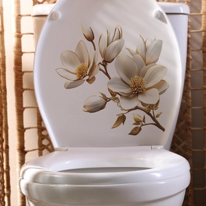 Close-up of elegant golden brown floral magnolia decals on a white bathroom toilet lid