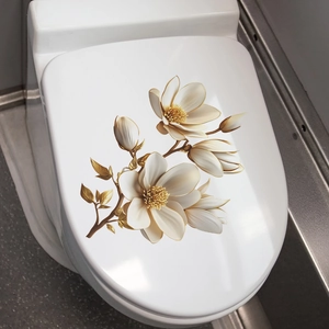 Close-up of golden and white magnolia floral wall stickers on a ceramic toilet lid
