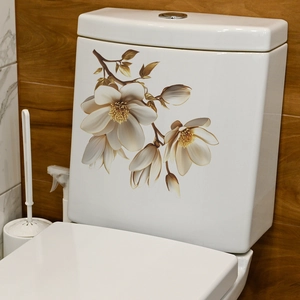 Elegant gold-edged white magnolia flower decals applied on a ceramic toilet tank surface