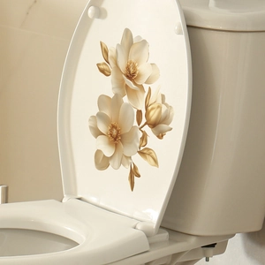 Detailed close-up of golden magnolia wall decal on a white ceramic toilet lid