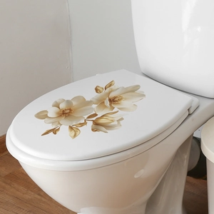 Detailed view of elegant golden magnolia flower decals applied on a white toilet lid