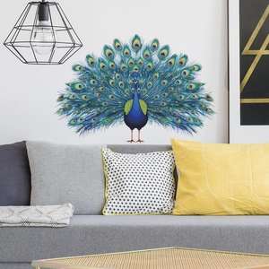 Vibrant blue peacock feather wall decal displayed above a modern grey sofa in a living room