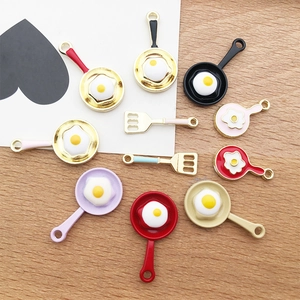 Detail of colorful frying pan and spatula charms for DIY jewelry making accessories