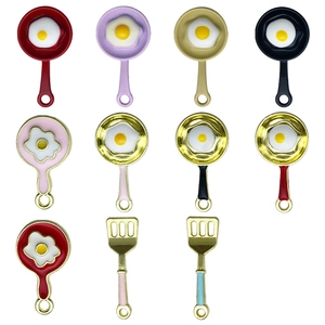 Detailed grid view of mini enamel fried egg pan and spatula charms for DIY jewelry