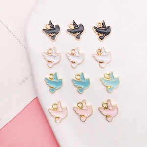 Détail de pendentifs pigeons en alliage émaillé avec anneaux dorés en plusieurs couleurs