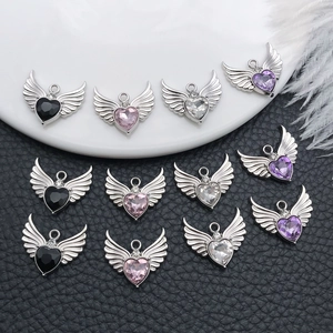Macro detail of angel wing heart charms in black, pink, purple and clear crystals