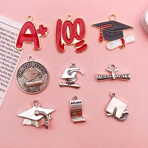Macro detail of assorted graduation charms including enamel A plus and silver mortarboard