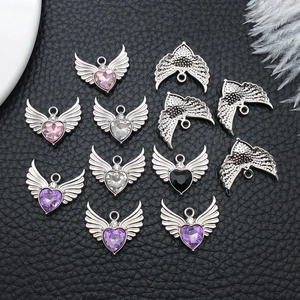 Detail view of heart-shaped wing charms with colorful zircon inlay for DIY jewelry