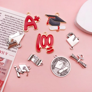 Flat lay of alloy graduation charms with A+ scores, mortarboards, and diploma scrolls