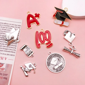 Detailed macro view of graduation charms including cap, diploma, and red A plus pendants
