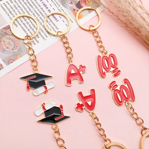 Close-up of alloy graduation keychains with A+, 100 points, and mortarboard charms