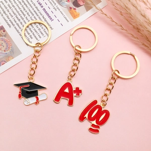 Golden alloy graduation keychains set featuring mortarboard hat with A plus and 100 mark