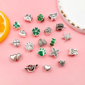 Detalle de dijes de aleación de plata con formas de mariposa y corazón para joyería artesanal