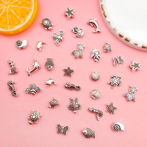 Detailopname van antieke zilveren zeedierbedeltjes voor DIY-sieraden en armbanden
