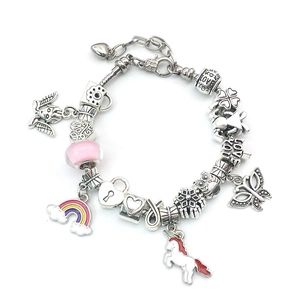 Detalle de pulsera de dijes plateada con unicornio arcoíris y colgantes de corazón amor
