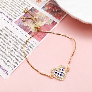 Pulsera dorada ajustable con un colgante de corazón de cuadros azules y blancos