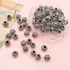 Macro shot of vintage silver hollow metal spacer beads with intricate floral engravings