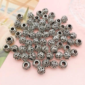 Detailed close-up of 9mm hollow antique silver beads with floral and heart patterns