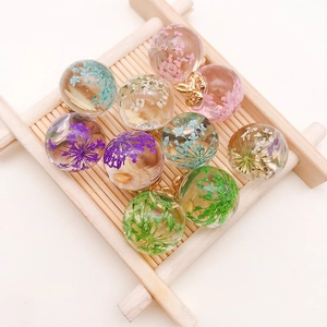 Macro shot of assorted glass bottle charms with dried flowers and gold metal caps