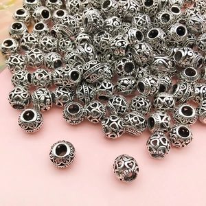 Macro shot of silver alloy hollow beads with heart and floral patterns for DIY jewelry