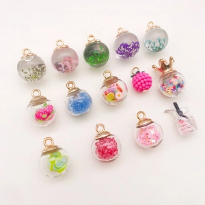 Detail view of assorted glass bottle charms with colorful sequins and fruit slices inside