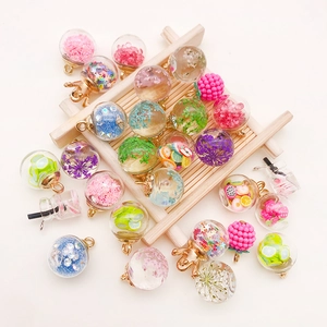 Macro view of colorful crystal glass bottle charms with fruit and star glitter fillings