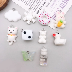 Flat lay of 10 white resin charms including bear, duck, and cat for DIY jewelry making