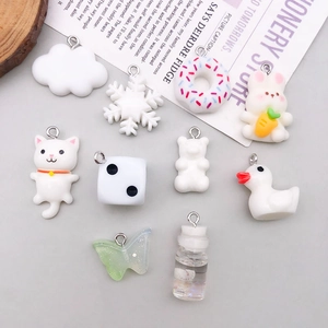 Flat lay of white resin animal and dessert charms including rabbits and ducks for DIY jewelry