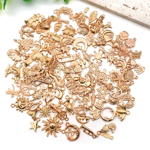 Flat lay of diverse gold alloy charms for DIY jewelry making with holiday and nature motifs