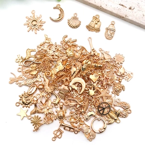 Macro detail of mixed gold alloy pendants including sun and moon shapes for DIY jewelry