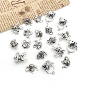 Vista macro de dijes de tetera de plata retro con grabado para crear joyas artesanales